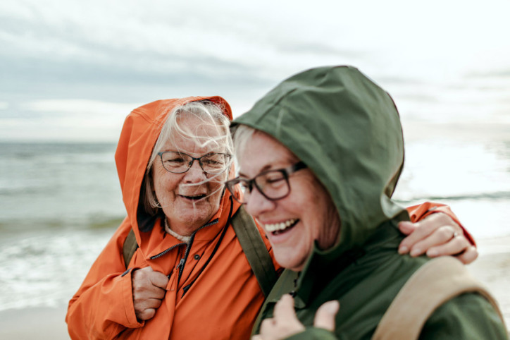 Zwei Seniorinnen stärken ihr Immunsystem bei einem Strandspaziergang