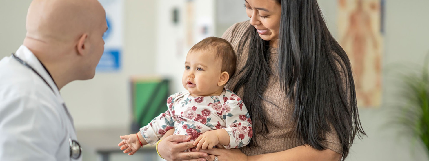 Ein Facharzt für Frauenheilkunde und Geburtshilfe im SRH Klinikum Naumburg spricht mit einer Patientin und ihrem Baby. 