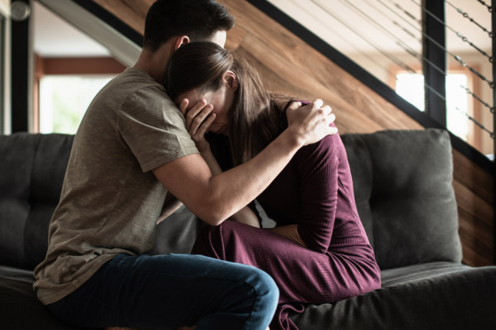 Eine trauernde Frau wird von ihrem Partner getröstet