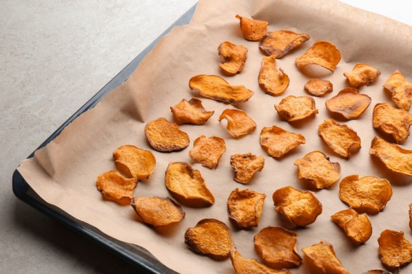 selbstgemachte Gemüsechips, wahrscheinlich aus Kartoffeln, liegen auf einem backblech