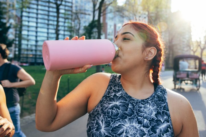 Eine Frau beugt bei heißen Temperaturen einer Dehydration vor