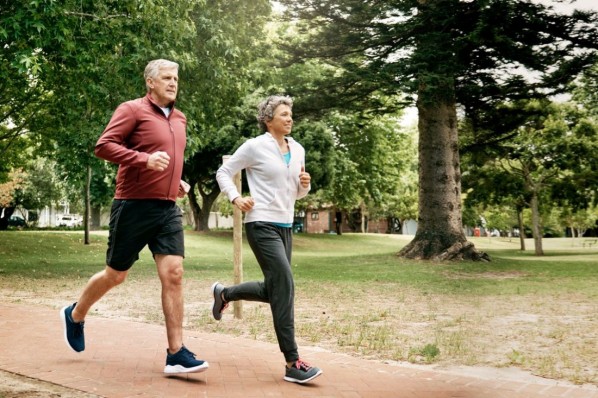 Ein Mann und eine Frau joggen gemeinsam im Park