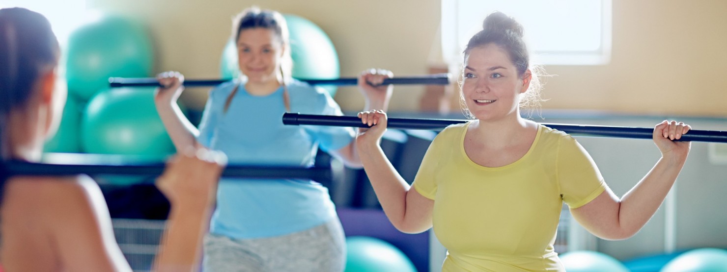 Drei Frauen machen zusammen Sport und mit grünen Gymnastikbällen im Hintergrund.