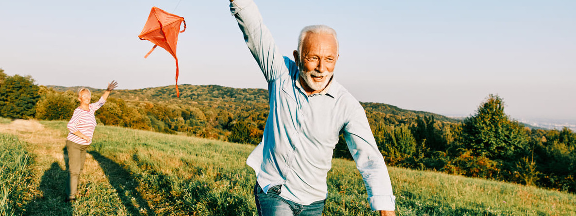 Ein vitaler Senior, der nach dem Longevity-Konzept lebt, lässt einen Drachen steigen