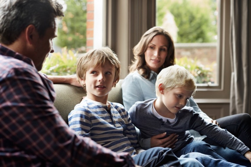 Familie mit 2 Söhnen auf dem Sofa