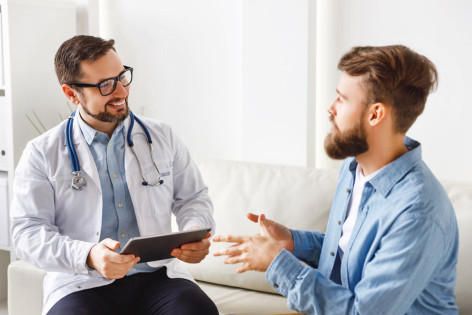 Ein Arzt zeigt seinem Patienten verschiedene Behandlungsmöglichkeiten.