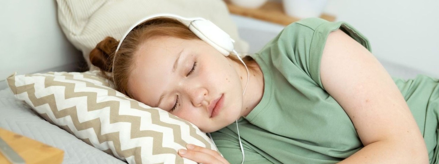 Ein Mädchen entspannt sich zu binauralen Beats auf dem Sofa.