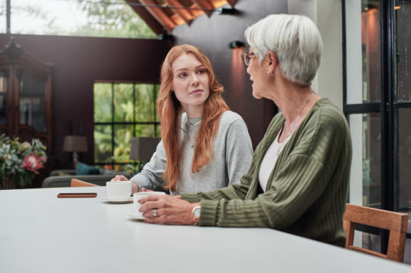 Junge Frau beim Kaffee mit ihrer älteren Mutter zu Hause