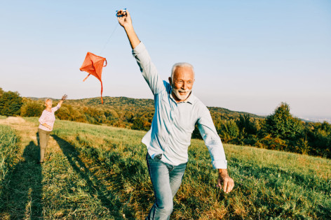 Ein vitaler Senior, der nach dem Longevity-Konzept lebt, lässt einen Drachen steigen