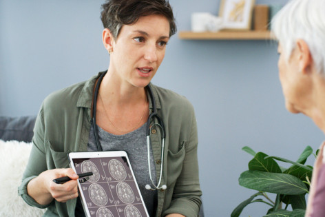 Eine Ärztin erklärt einer älteren Patientin, wie es zu einem Schlaganfall kommt