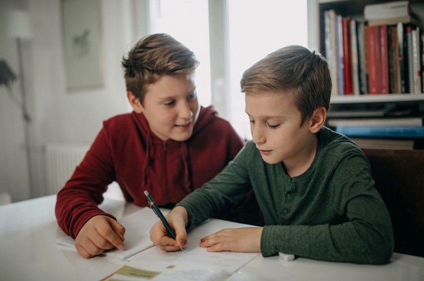 Zwei Jungen im Alter von 8 jahren lösen zusammen Schulaufgaben