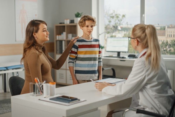 Eine Mutter ist mit ihrem ca. 10-jährigen Sohn beim Kinderarzt