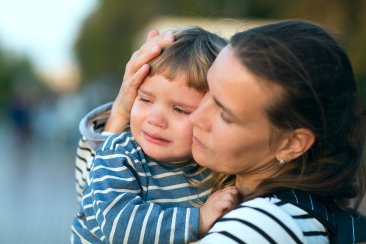 Eine Mutter tröstet ihr fremdelndes Kind.
