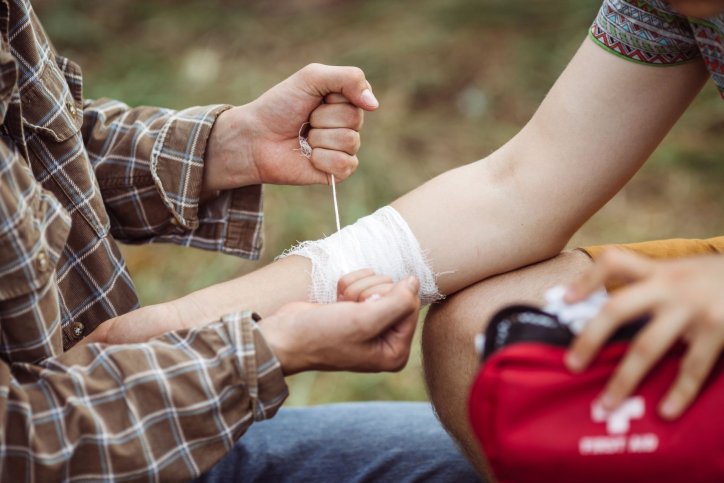 Eine Reiseapotheke liefert Verbandsmaterial um eine Armverletzung zu versorgen