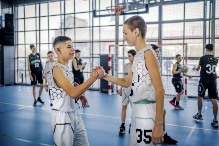Zwei jugendliche Sportler klatschen sich für ein Handballspiel ab.