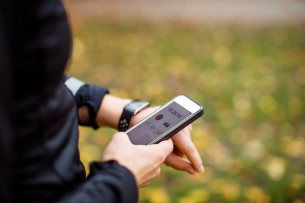 Ein Fitnesstracker zeigt den Puls beim Sport auf dem Smartphone ans