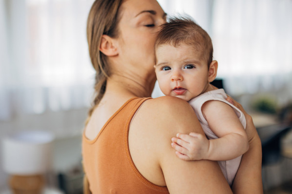 4 Monate altes Mädchen auf dem Arm seiner Mutter