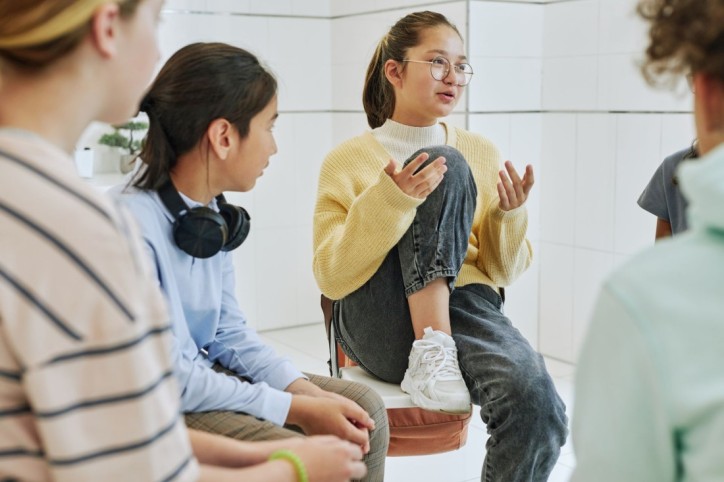 Eine Therapiegruppe von Jugendlichen spricht miteinander.