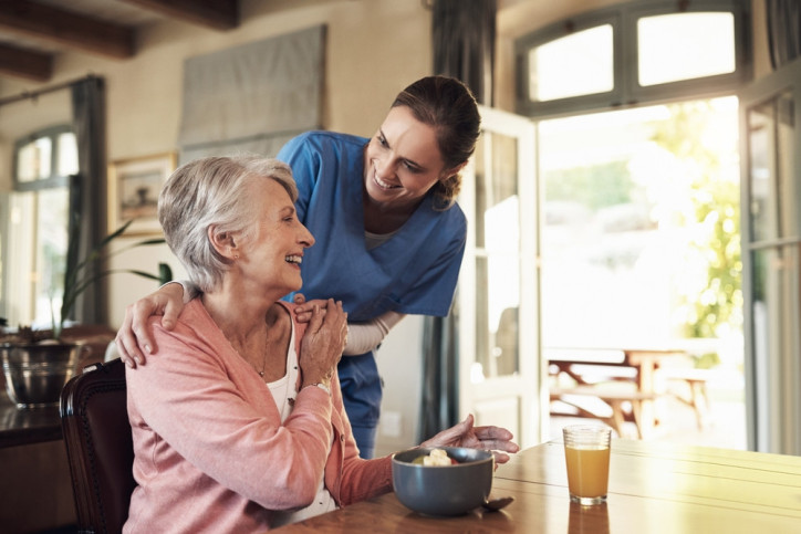 Eine Pflegefachkraft bereut eine Seniorin.