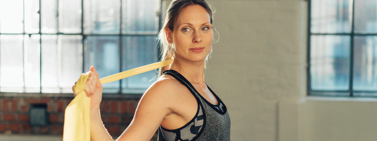 Frau beim Rückentraining im Fitnessstudio