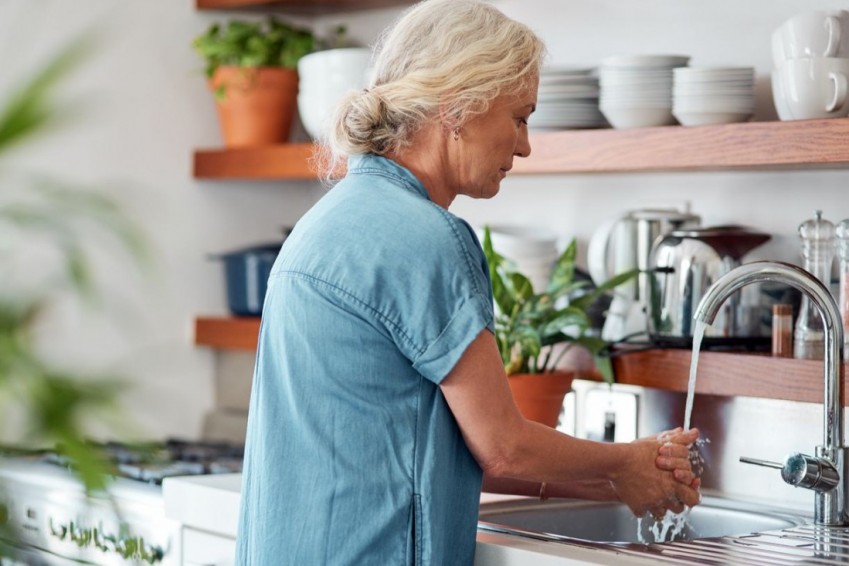 Eine etwa 60 jährige Frau wäscht ihre Hände.