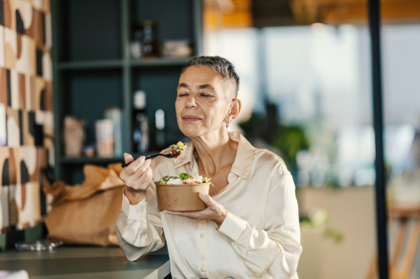 Eine Seniorin isst genussvoll einen Salat.