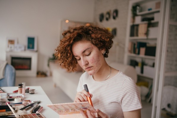 Photo of a young woman applying make-up