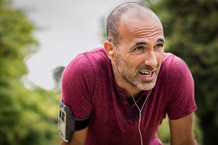 Mann Ende 40 kommt zu Atem nach dem Joggen