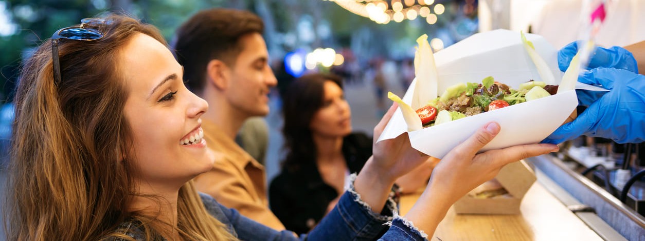Eine Frau probiert kulinarische Spezialitäten auf dem Streetfood-Festival