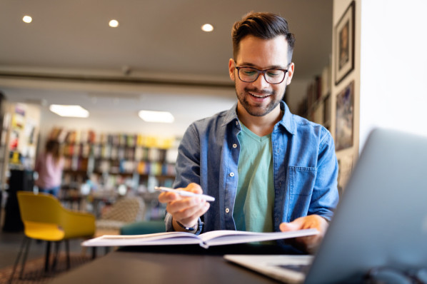 Student bereitet sich in der Bibliothek auf Vorlesung oder Prüfung vor