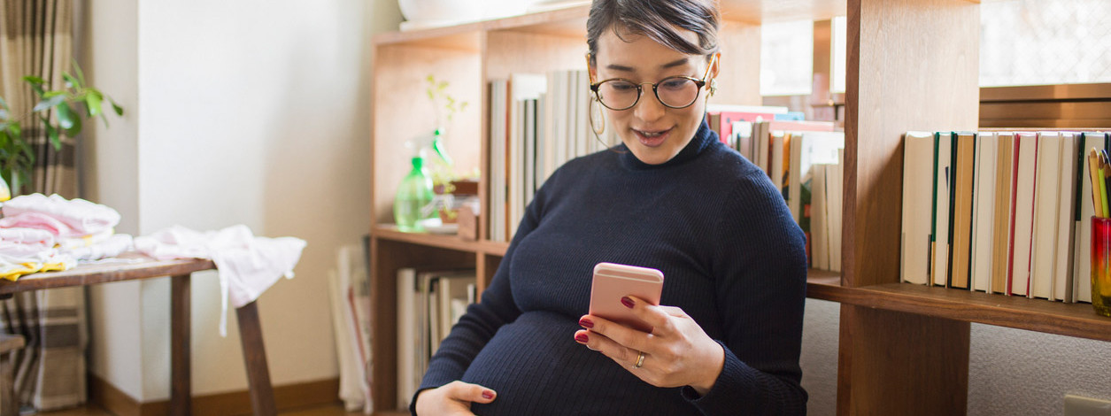 Junge Frau kommuniziert mit Kreßsaal über WhatsApp
