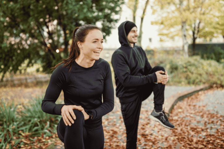 Junges Paar macht gemeinsam Sport im herbstlichen Park