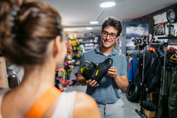 Eine Frau wird in einem Fachgeschäft zu Barfußschuhen beraten.