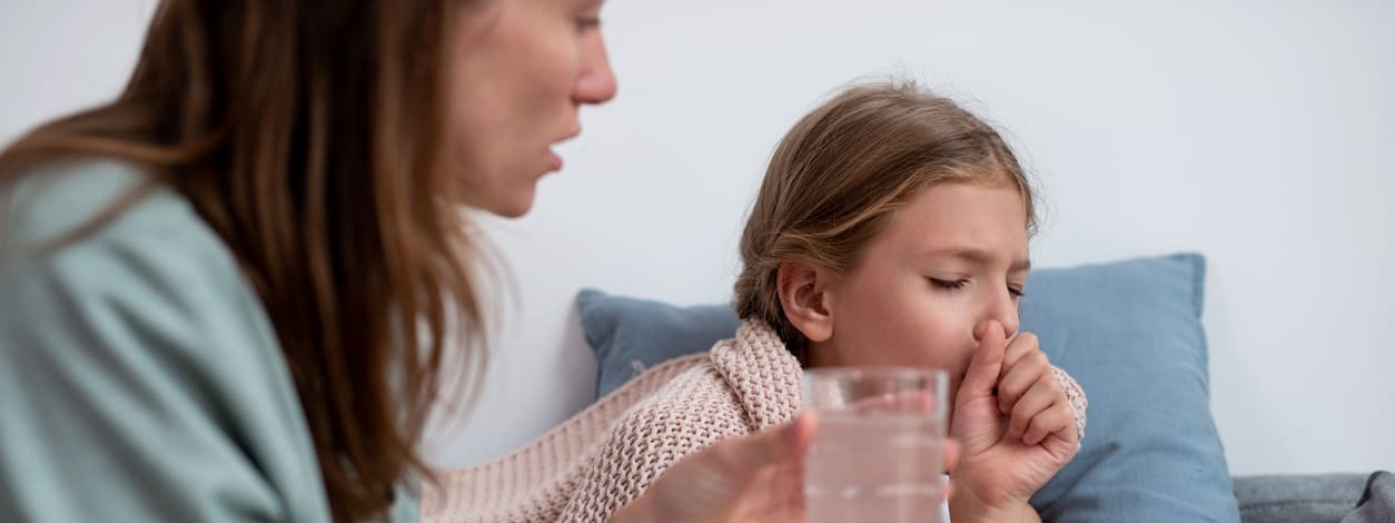 Eine Mutter pflegt ihre an Keuchhusten erkrankte Tochter