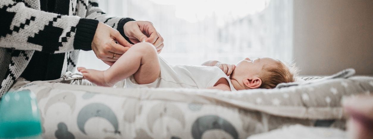 Eine Mutter wickelt ihr Baby auf dem Wickeltisch