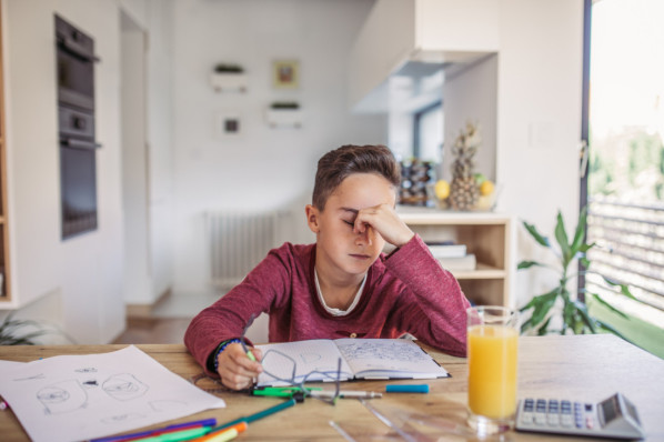 Junge ist gestresst von Schulaufgaben