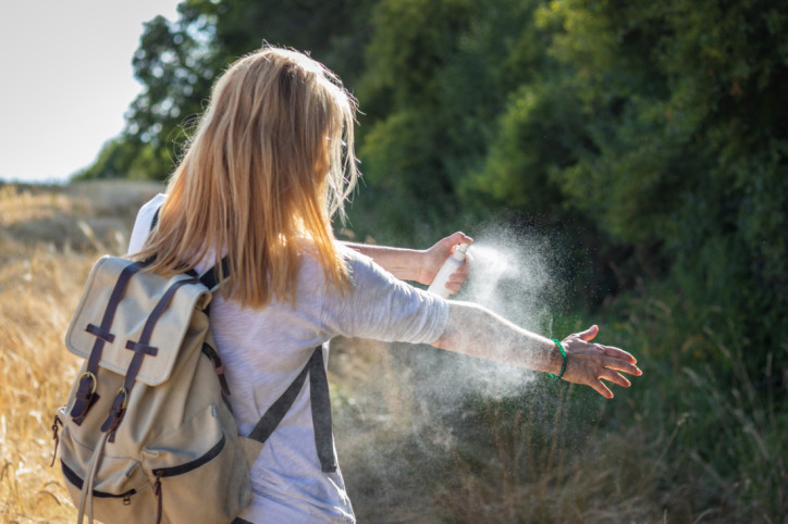 Frau nutzt Repellentien zum Mückenschutz.