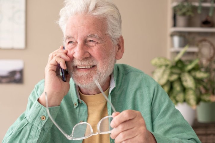 Ein lächelnder Rentner telefoniert.