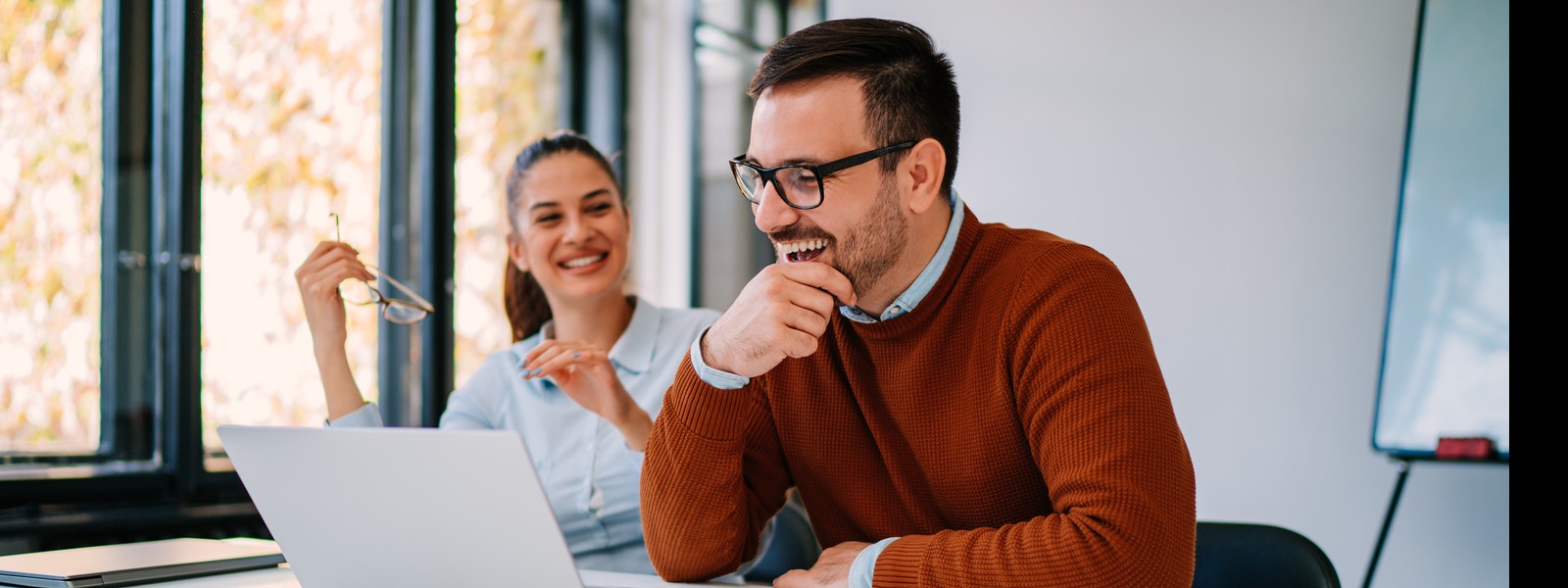 Two young businesspeople having fun while working together in the office