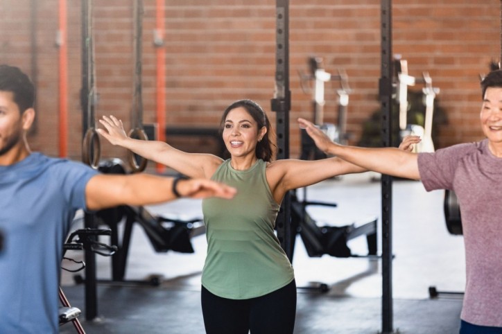 Junge Frau ist im Fitnessstudio und macht Kraftübungen.