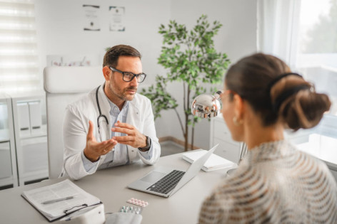 Ein Arzt berät eine Patientin zu einer Biopsie