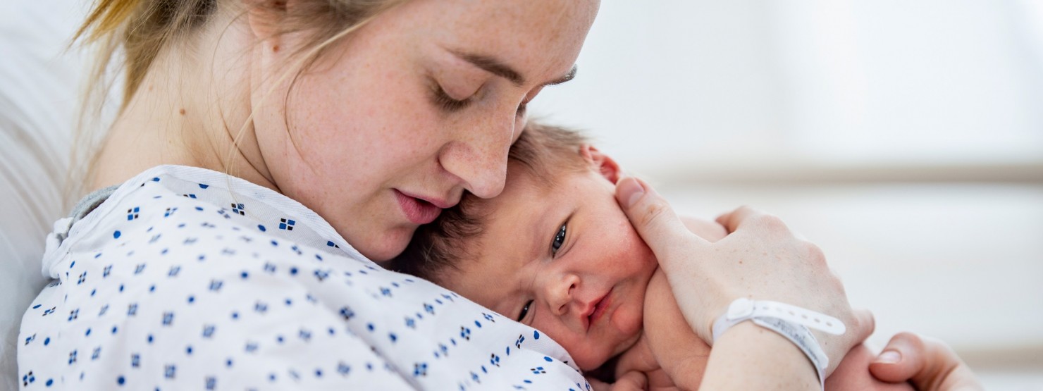 Frau hält ihr Baby in den Armen