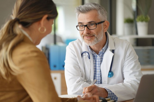 Patientin sitzt ihrem Hausarzt gegenüber