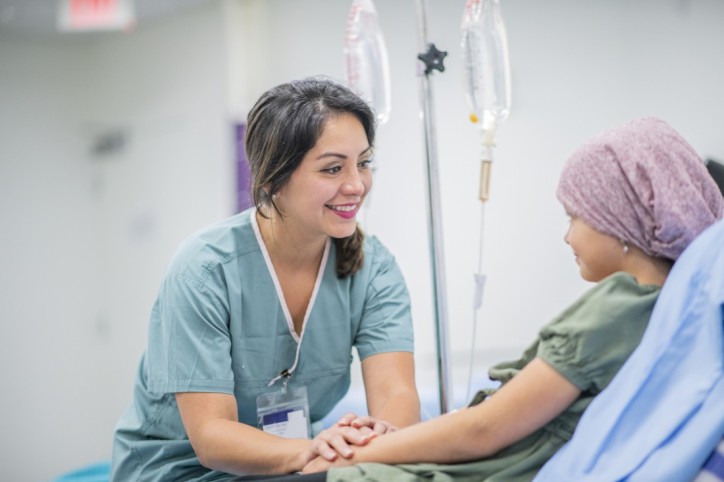 Krankenschwester kümmert sich um junge Krebspatientin.