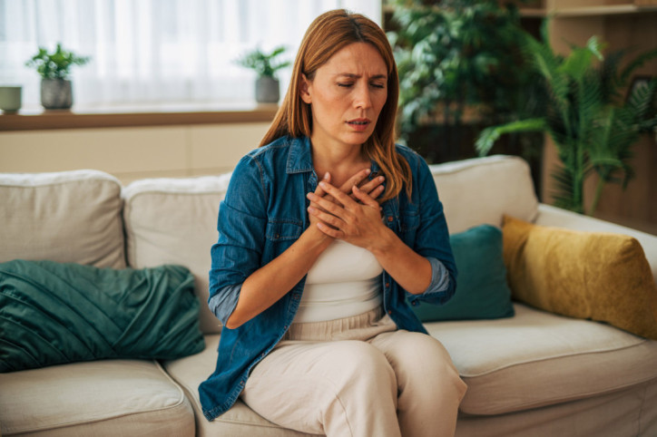 Eine Frau, die unter Klaustrophobie leidet, sitzt auf einem Sofa in einem engen Raum