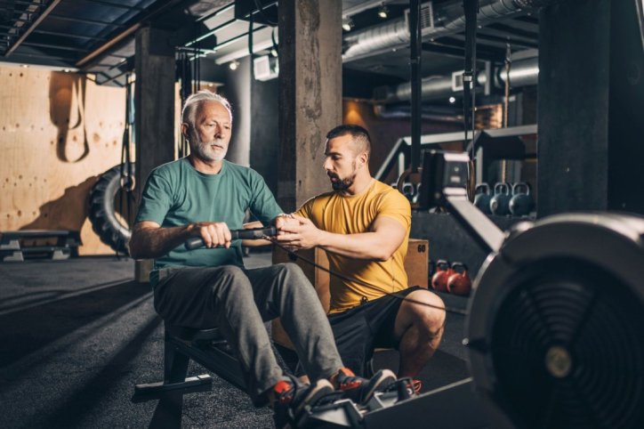 Ein Senior trainiert mit einem Fitness-Coach für HYROX