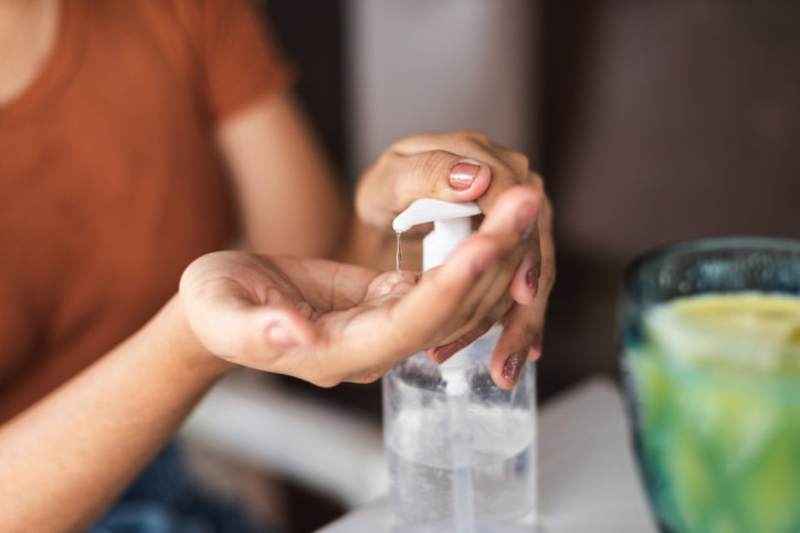 Eine Frau benutzt Handdesinfektion für eine effektive Handhygiene