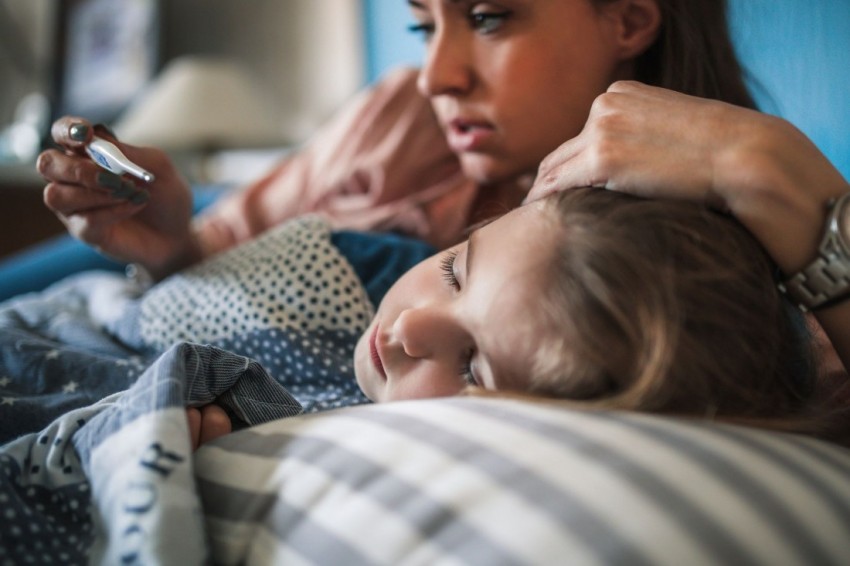 Eine Mutter streicht ihrer kranken Tochter über den Kopf.