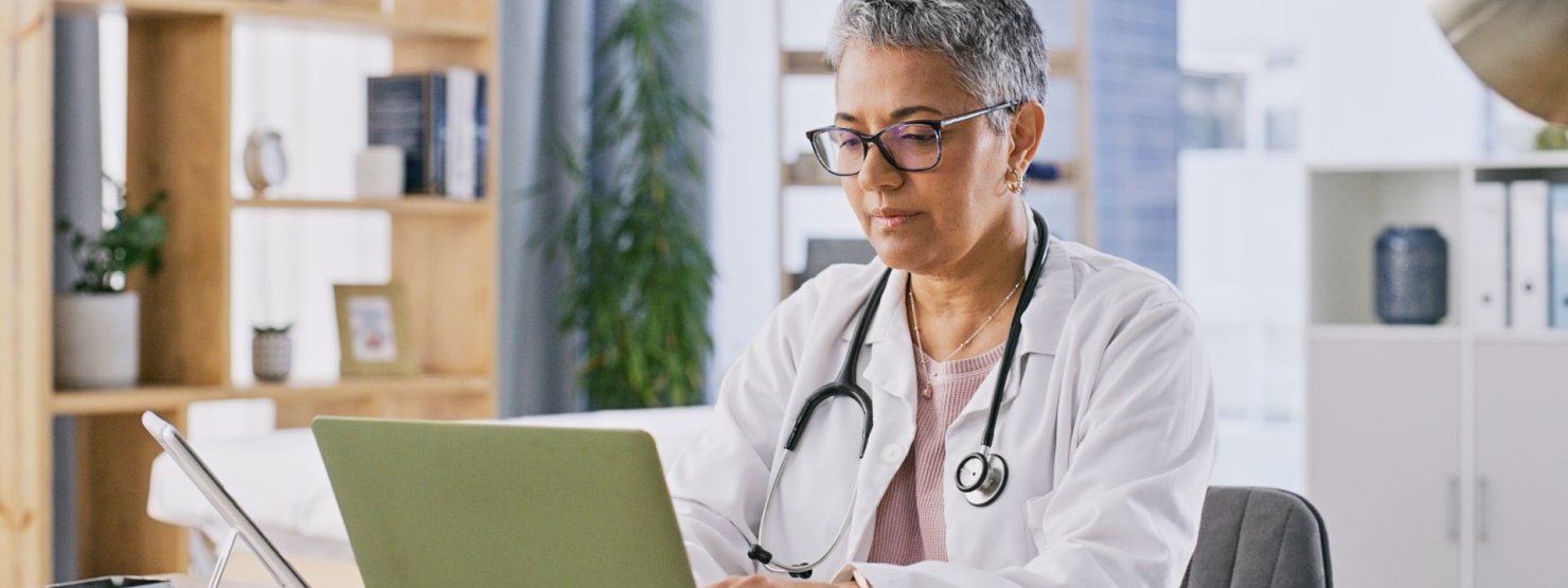 Eine Ärztin meldet am Laptop ein Fehlverhalten an die Krankenkasse.