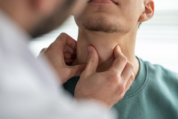 Ein Arzt tastet die Lymphknoten eines Mannes ab